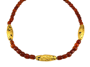 Necklace with three gold gilded oblong lava beads evenly spaced between pecan colored amber beads laid out in a circle close up.