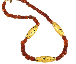 Looking on top of Necklace with three gold gilded oblong lava beads evenly spaced between pecan colored amber beads.