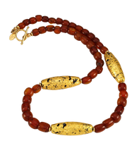 Load image into Gallery viewer, Looking straight down on Necklace with three gold gilded oblong lava beads evenly spaced between pecan colored amber beads, and finished with a 14 karat gold filled toggle clasp.