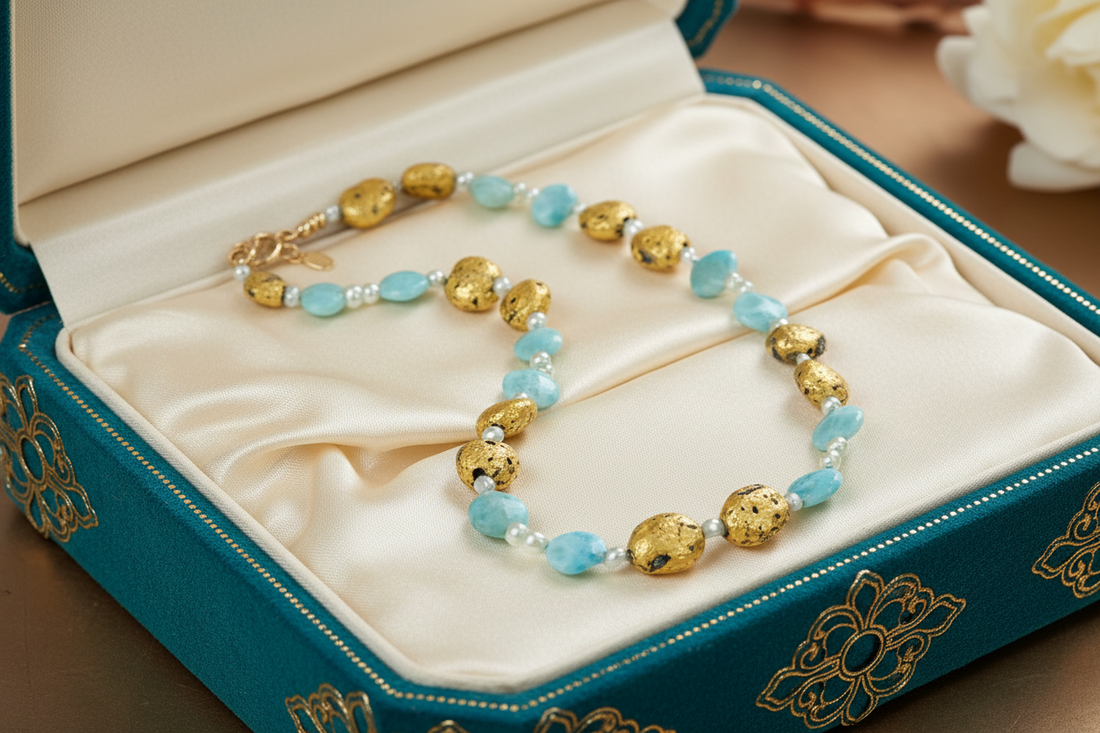Blue larimar and gold necklace on cream sstin in a beautiful blue jewelry  box