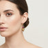 Gold and ruby earring on model.