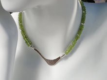 Load image into Gallery viewer, Hammered silver abstract pendant necklace with two strands of faceted peridot and silver beads. The necklace is finished with a magnetic clasp and the artist&#39;s signature tag. The necklace measures 17&quot; (43.18cm). The necklace is displayed on a white mannequin neck.