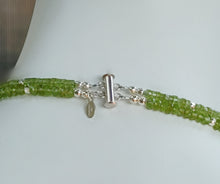 Load image into Gallery viewer, Hammered silver abstract pendant necklace with two strands of faceted peridot and silver beads. The necklace is finished with a magnetic clasp and the artist&#39;s signature tag. The necklace measures 17&quot; (43.18cm). The necklace is displayed on a white mannequin neck showing a closeup of the clasp.