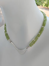 Load image into Gallery viewer, Hammered silver abstract pendant necklace with two strands of peridot and silver beads. The necklace is finished with a magnetic clasp and the artist&#39;s signature tag. The necklace measures 17&quot; (43.18cm). The necklace is displayed on a white mannequin neck.
