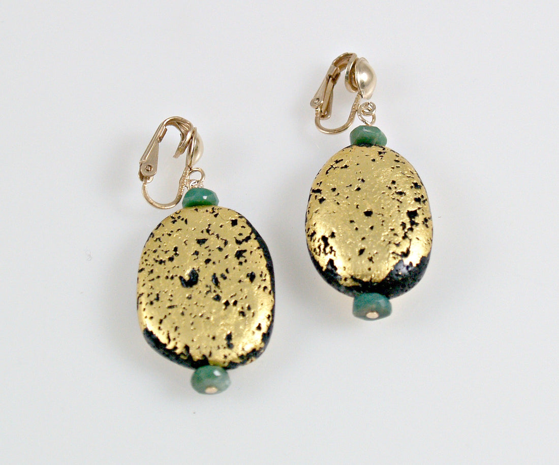 A pair of clip earrings featuring a gilded gold lava stone with green chrysoprase accents.